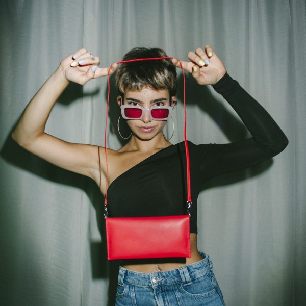 Femme montrant un sac baguette rouge de la marque végan « Walk with Me ».