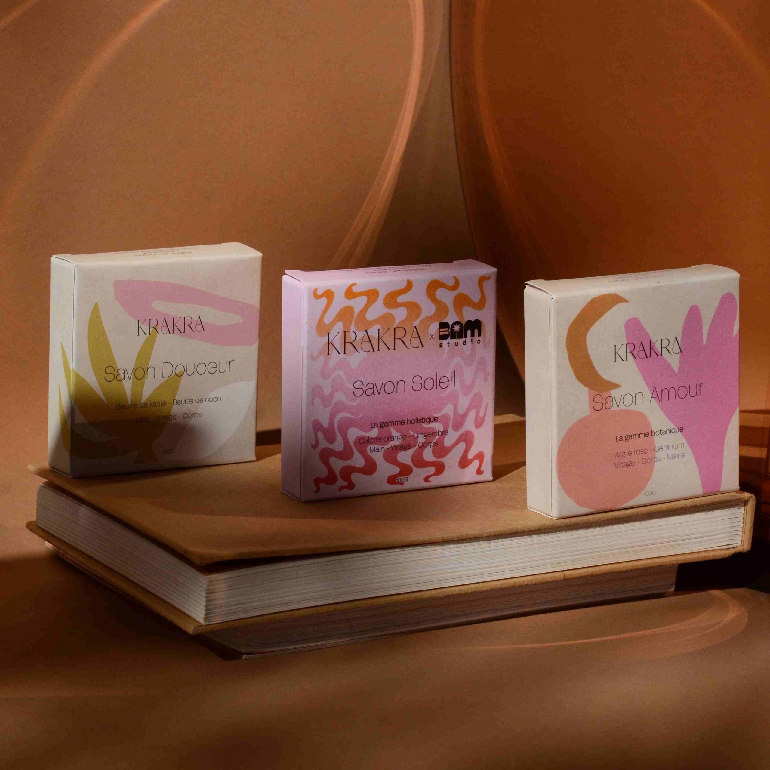 Image de campagne représentant trois savons pour les mains, le visage et le corps de la marque de cosmétique Krakra.